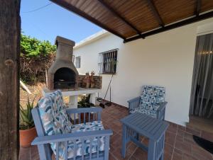 a patio with two chairs and a fireplace at Livingtarifa Casa Luz in Facinas
