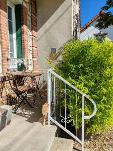 a cat standing next to a fence on a porch at Le temps d'une pause -1- in Cepoy