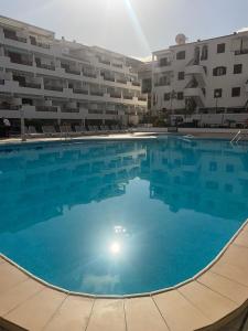 a large swimming pool in front of a building at Apartamento de 1 dormitorio en Victoria Court 2 Los Cristianos. in Los Cristianos