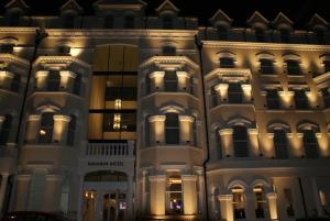 a lit up facade of a building at night at Mannin Hotel in Douglas