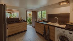 a kitchen with a sink and a washing machine at Beach apartment, Ti Clé de Lo in Pointe-Noire +17 photos