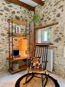 a room with a rocking chair and a desk at Stunning Boutique gîte Flore at Vive le Vert in Bussière-Badil