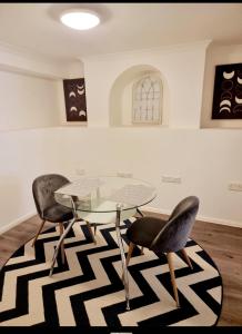 a dining room with a glass table and two chairs at Kent 1 bedroom apartment 2 mins walk to Gravesend Station & Town Centre in Gravesend +12 photos