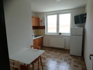 a kitchen with a table and a white refrigerator at Ubytovaniezm in Zlaté Moravce