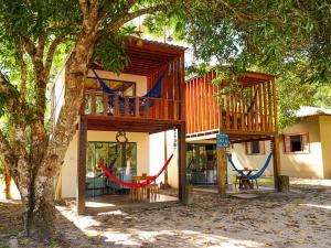 菲格雷多总统镇Pousada Paraíso do Calango Azul的一栋带露台、前面有吊床的房子
