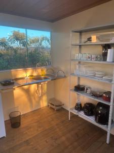 una cucina con un lavandino e una finestra di Chalé cabana de ferro a Alto Paraíso de Goiás