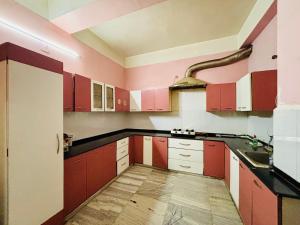 a kitchen with red and white cabinets and a sink at Blue Vista Homestay in Guwahati