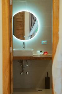 a bathroom with a sink and a mirror at Balungi Boutique Hotel in Uroa