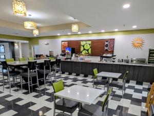 a restaurant with tables and chairs and a counter at La Quinta by Wyndham Prattville in Prattville