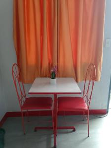 a white table with two chairs and a potted plant at Wjv Inn Talamban in Cebu City +24 photos