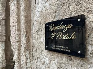 a sign on the side of a stone wall at Il Portale 2 in Tropea