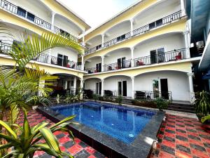 a view of the courtyard of a building with a swimming pool at Morjim Sunset Hotel in Morjim +49 photos