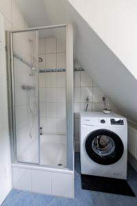 eine Waschmaschine in einem Badezimmer mit Dusche in der Unterkunft SeeNah Apartments, Komfort mit Einkaufsmöglichkeiten & Parkplatz in Bad Zwischenahn + 69 Fotos