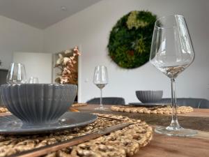 ein Tisch mit zwei Weingläsern und einem Teller mit Essen in der Unterkunft City Apartment 1 in Bad Nenndorf