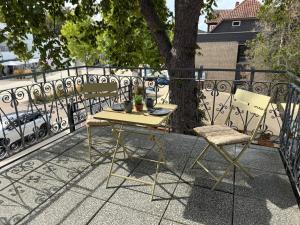 ein gelber Tisch und zwei Stühle auf einem Balkon in der Unterkunft City Apartment 1 in Bad Nenndorf
