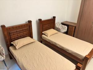 a bedroom with two beds and a desk and a chair at Illam at Adyar in Chennai