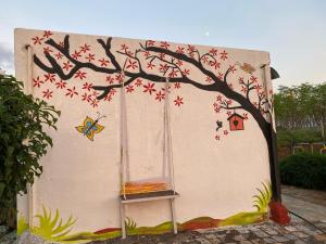 a house with a tree painted on the side of it at Mangal Srushti Agro Tourism  +6 photos