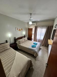 a hotel room with two beds and a window at Nuevo Hotel Córdoba in Villa Carlos Paz