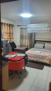 Un dormitorio con una cama, un escritorio y una mesa. en Purity Apartments, en Nairobi