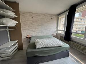 Un dormitorio con una cama y una ventana grande en Appartement Hérouville, en Hérouville-Saint-Clair