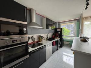 una cocina con electrodomésticos en blanco y negro y una ventana en Appartement Hérouville, en Hérouville-Saint-Clair