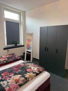 a bedroom with a bed and a cabinet and a window at City Apartment 2 in Bad Nenndorf