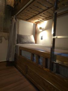 a bedroom with a wooden bed in a room at Narjiss Hostel in Fès