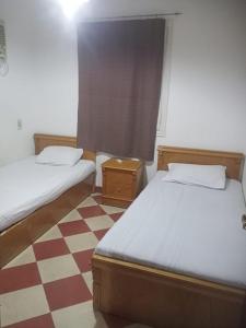 a bedroom with two beds and a checkered floor at Riviera Apartment in Sharm El Sheikh