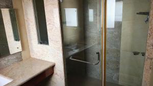 a shower with a glass door in a bathroom at vaibhav farm house in Govindgarh Malkpur +9 photos