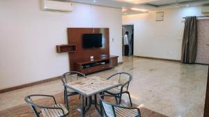a room with a table and chairs and a tv at vaibhav farm house in Govindgarh Malkpur