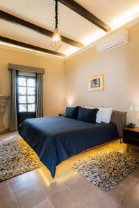 Un dormitorio con una gran cama azul y una ventana en Casa Studio San Miguel de Allende, en San Miguel de Allende