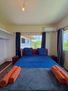 ショルシェールにあるVilla Yamaïra - Piscine, vue mer & billardのベッドルーム1室(青いベッド1台、オレンジ色の枕2つ付)