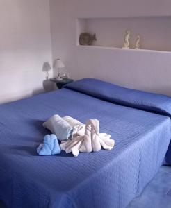 a blue bed with two stuffed animals on it at Appartamenti nel cuore di Vulcano Eolie in Vulcano