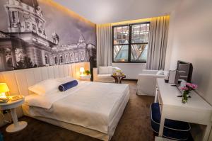 um quarto de hotel com uma cama grande e uma secretária em Hotel Passport em Belgrado