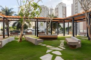 a park with benches and trees and buildings at Suíte Black Premium in Goiânia