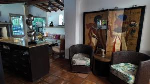 a living room with chairs and a painting on the wall at Hacienda del Lago Boutique Hotel in Ajijic