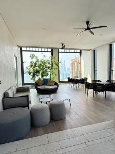 a living room with couches and tables and windows at Lucentia Suites Bukit Bintang Kuala Lumpur in Kuala Lumpur