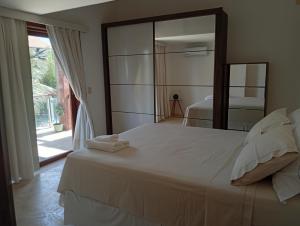 ein Schlafzimmer mit einem großen weißen Bett und einem Spiegel in der Unterkunft Taibá Beach Resort casa térrea ou chalet enteiro in Taíba + 68 Fotos