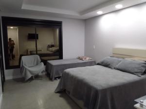 a hotel room with two beds and a mirror at StudioD in Passo Fundo