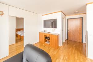 sala de estar con silla y TV en Hochwertige Apartments im Stralsunder Hafen, en Stralsund