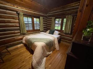 Un dormitorio con una cama en una cabaña de troncos en 3-Bedroom Cottage #7 - Balsam Lake, en Kawartha Lakes