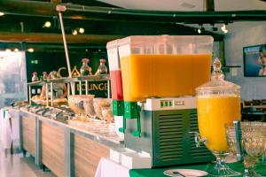 a machine with two glasses of orange juice on a counter at Cabana's Acqua Hotel in Águas de Lindoia