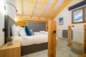a bedroom with a large bed and a wooden ceiling at Newly renovated luxury penthouse - central Morzine in Morzine