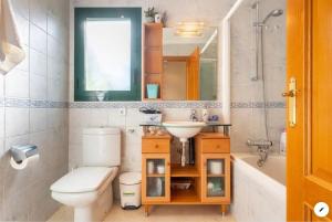 a bathroom with a toilet and a sink and a tub at Piso bonito cerca de la playa con piscina, jardín, gimnasio y garaje in Jávea