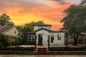 a house with a fence in front of a sunset at Gated 5BR Duplex Med Center Downtown NRG in Houston