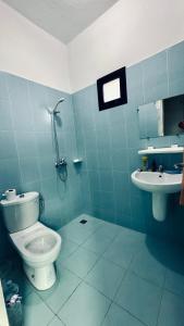a blue bathroom with a toilet and a sink at CHIC cozy appart bonoumin in Abidjan +10 photos
