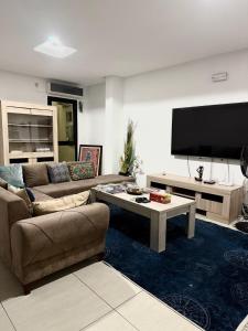 a living room with a couch and a tv at CHIC cozy appart bonoumin in Abidjan