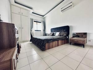 a bedroom with a bed and a dresser in it at CHIC cozy appart bonoumin in Abidjan