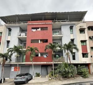 an apartment building with palm trees in front of it at CHIC cozy appart bonoumin in Abidjan