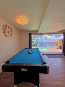 ショルシェールにあるVilla Yamaïra - Piscine, vue mer & billardのビリヤード台と時計付きの部屋